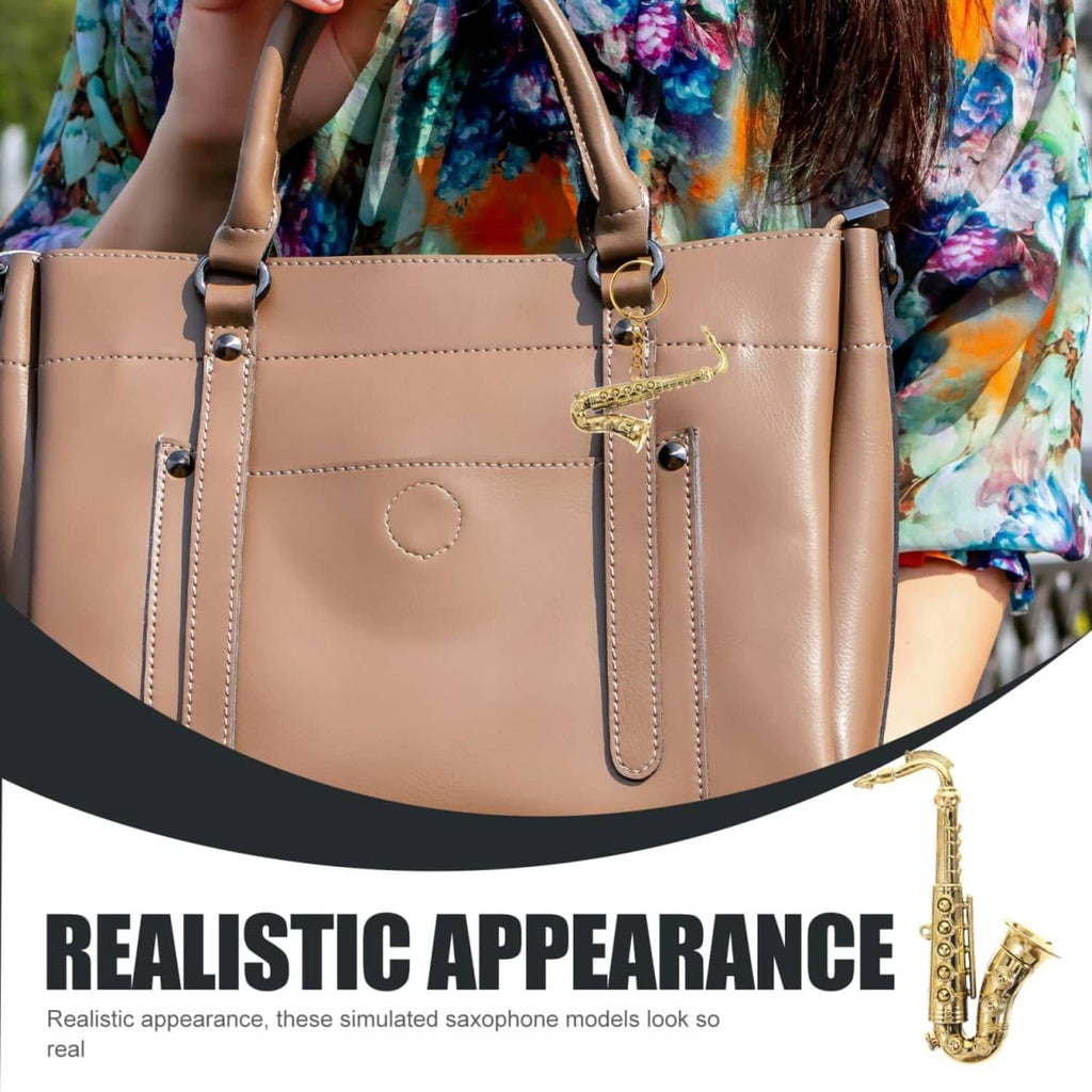 Gold mini saxophone charm on a tan handbag strap