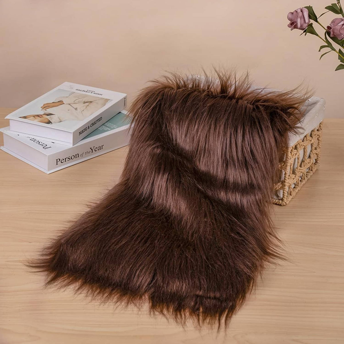 Brown faux fur fabric square folded, showing plush pile on a work surface.