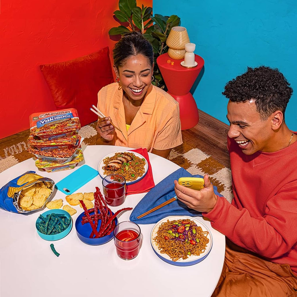 Yak isoba noodle bowls and sauce cups with chopsticks on a table
