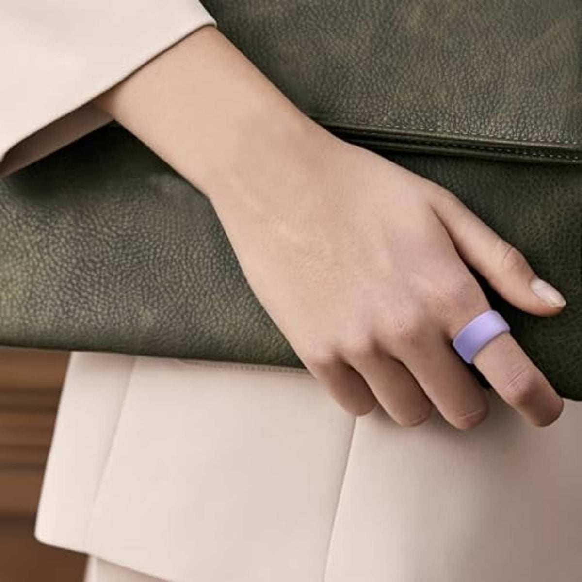 Lavender silicone ring cover on a finger, with open display window and dark housing
