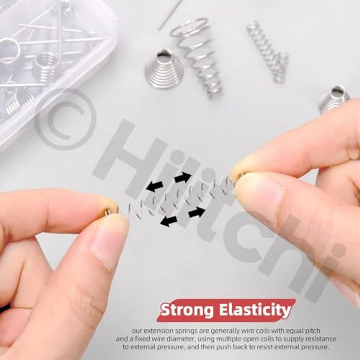 Assorted compressed coil springs showing strong elasticity, with small springs held by hands