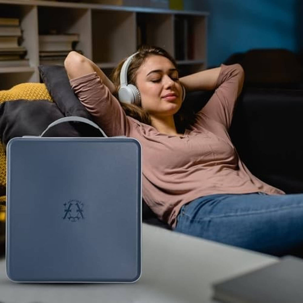 Dark blue hard CD/DVD case with carry handle, resting on a couch near a person.