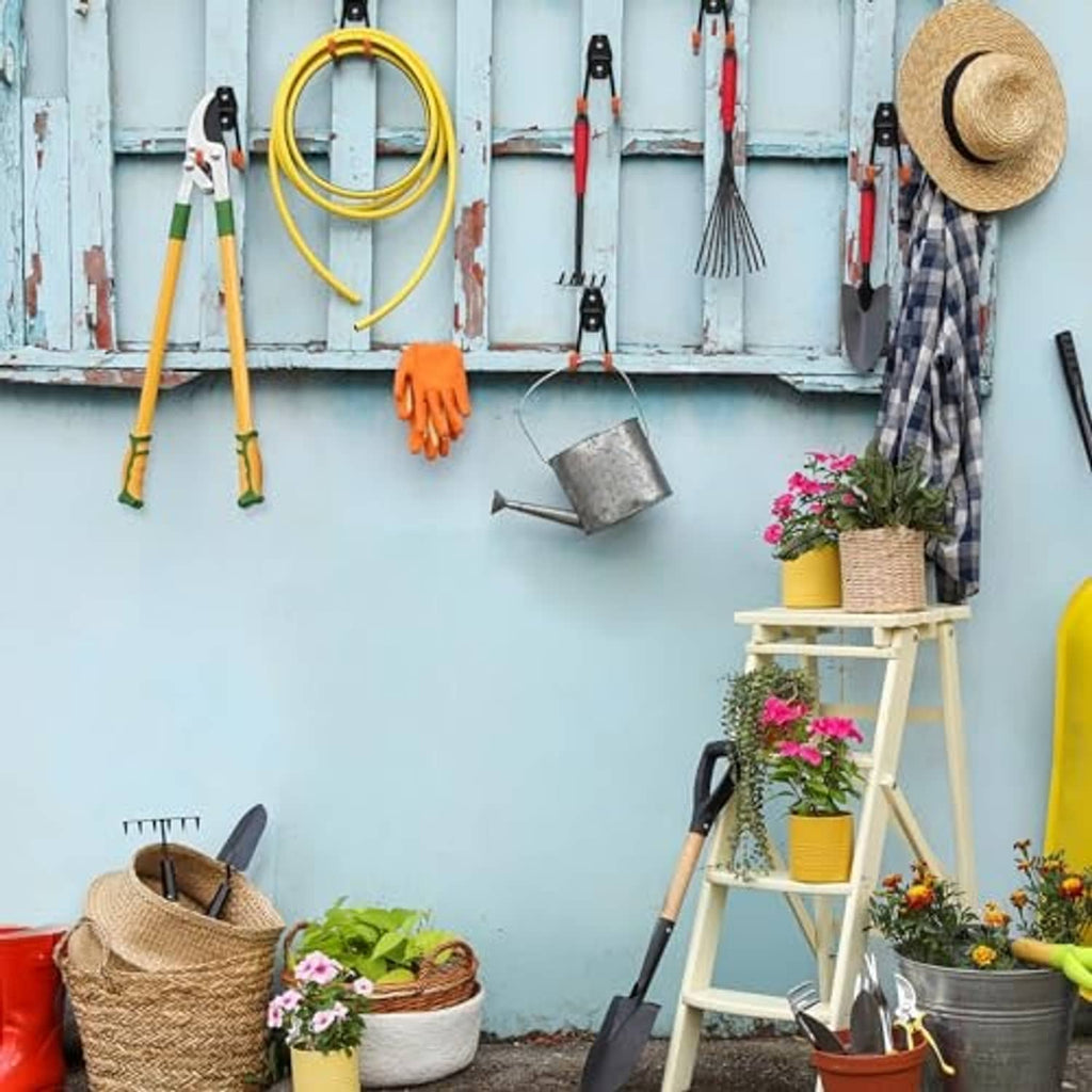 Multiple orange and black U-hook garage hooks mounted on a wall for tools.