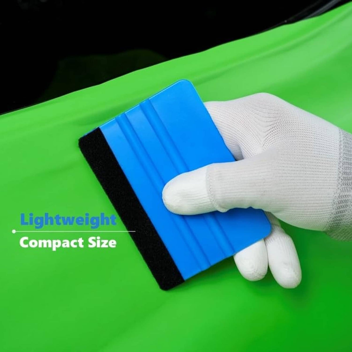 Blue felt-edge squeegee tool with black felt strip, held by gloved hand