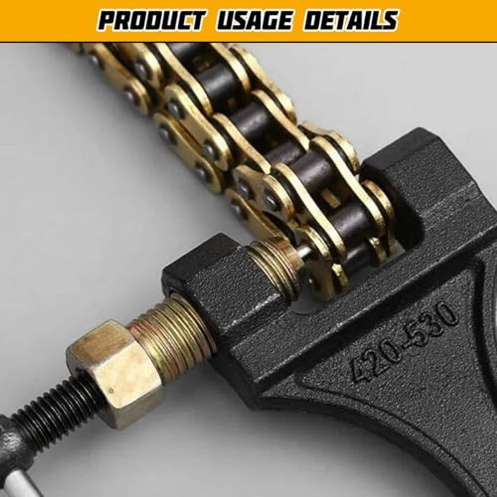 Motorcycle chain breaker tool close-up: black body, brass pin, and threaded screw assembly