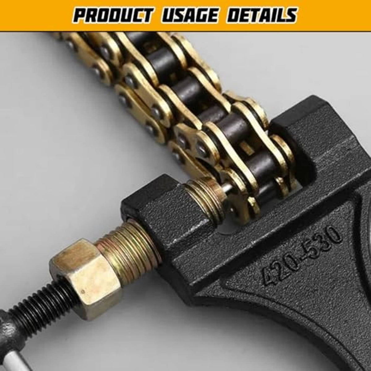 Motorcycle chain breaker tool close-up: black body, brass pin, and threaded screw assembly