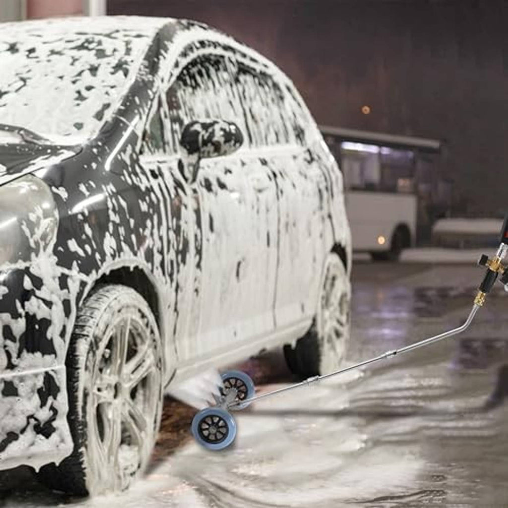 Undercarriage cleaner wand spraying foam near vehicle wheel with extension nozzle