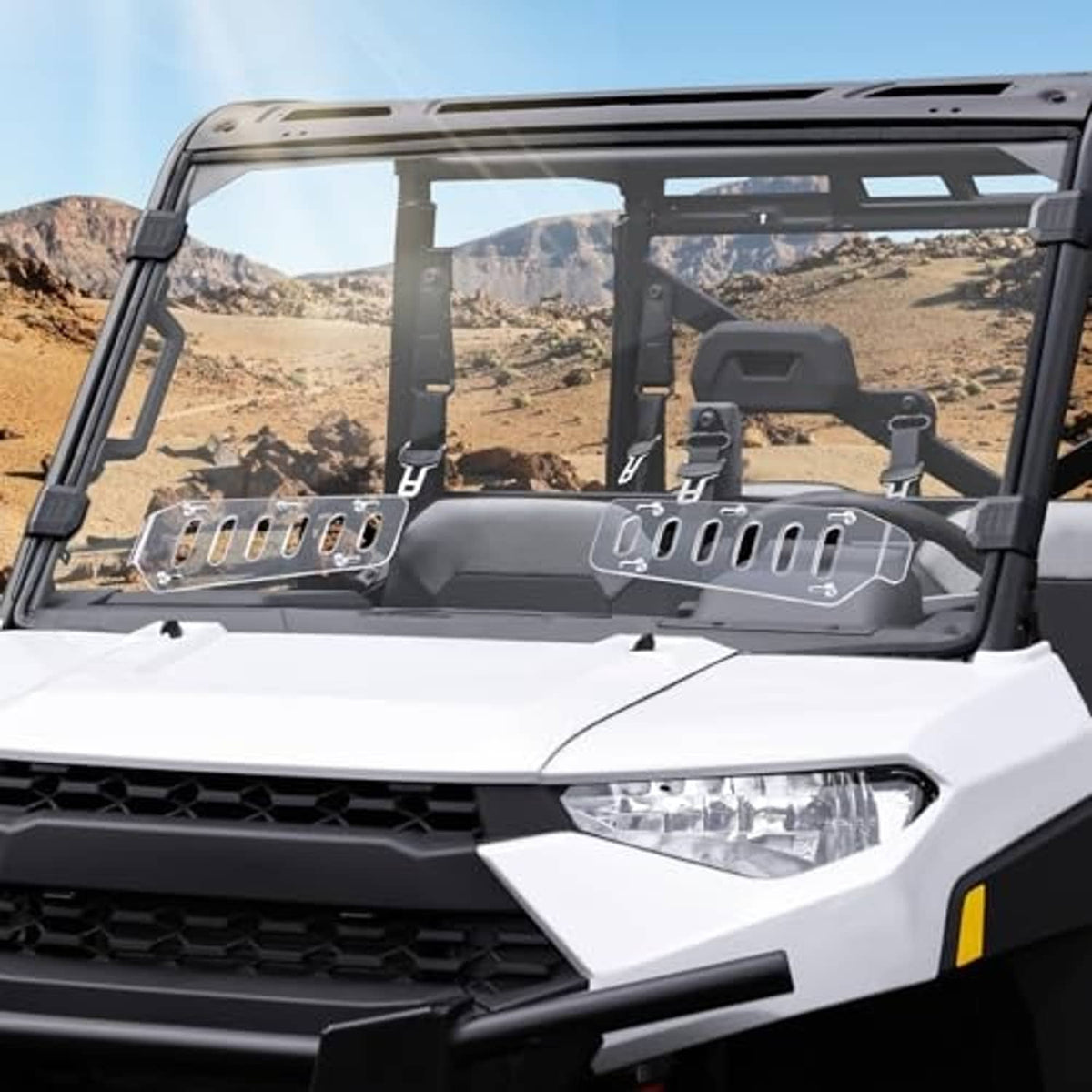 Vented clear windshield with dark brackets installed on an off-road UTV cab, close front.
