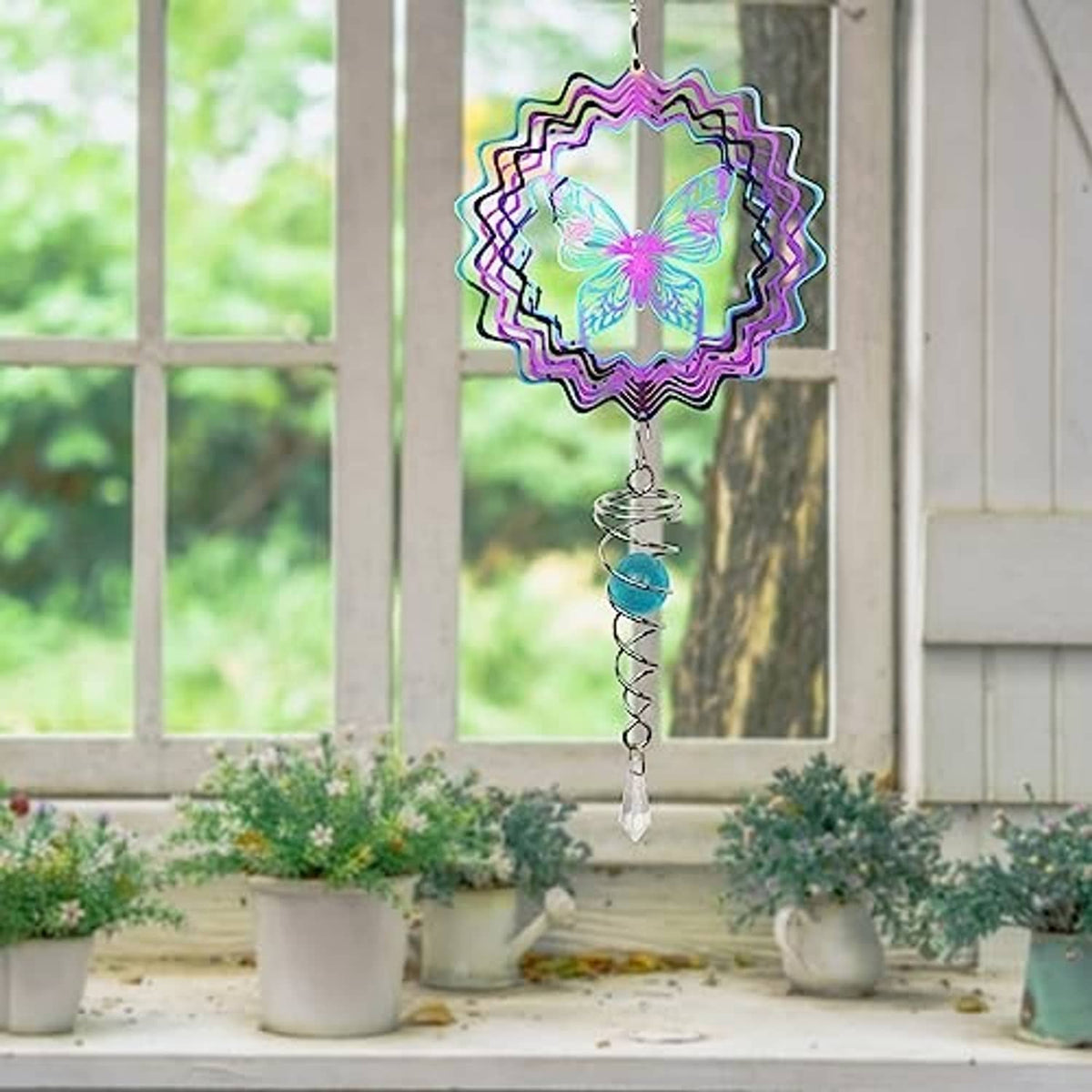 Butterfly wind spinner hanging from a hook, multicolor ruffled disc and blue orb spiral tail