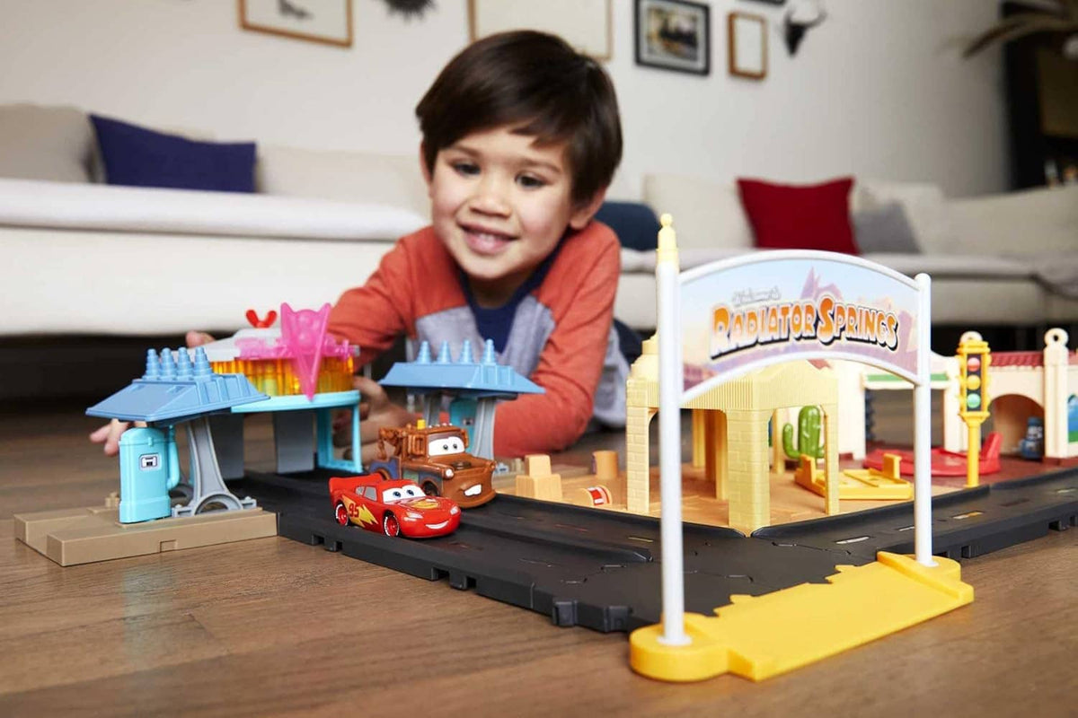 Cars track playset with two toy cars and colorful buildings, set up for play