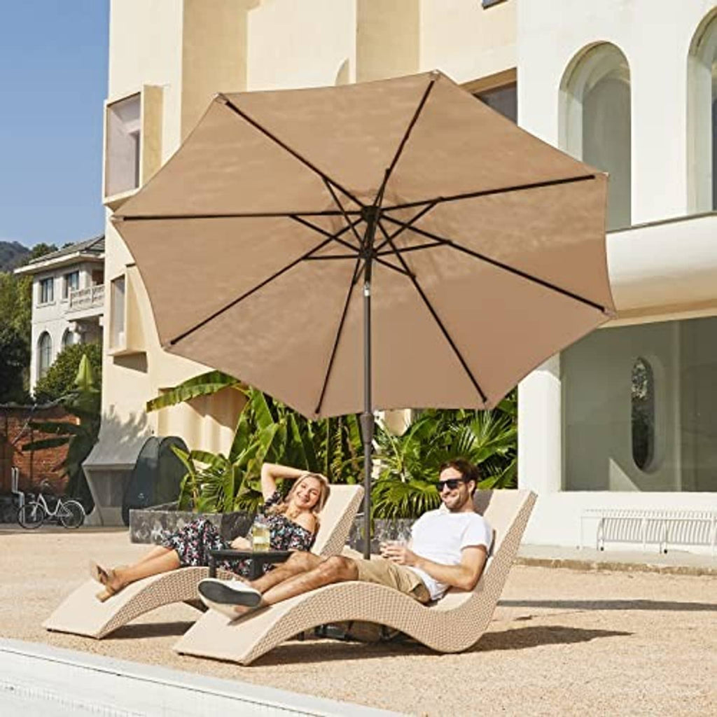Beige patio umbrella open above two lounge chairs with round push button crank