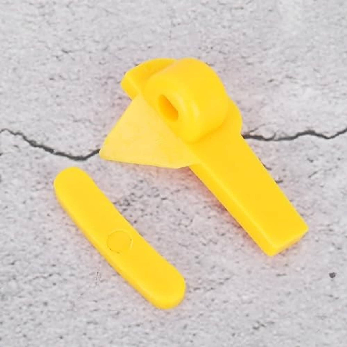 Pair of yellow tire demount head tools with handle clips, close-up on surface