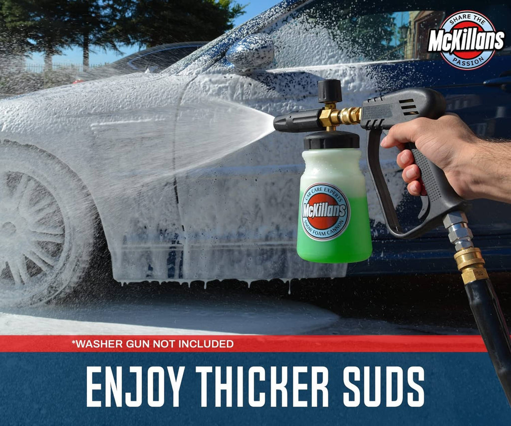 Close-up foam cannon sprayer producing thick foam spray from a green soap bottle