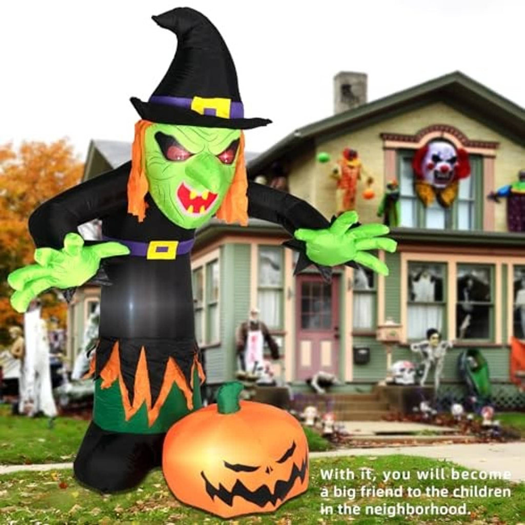 Inflatable Halloween witch with green face, black hat, and jack-o'-lantern belly