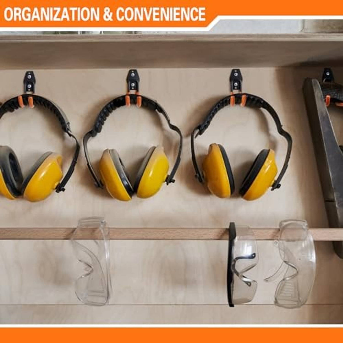 Three black J-hook garage hooks holding ear protection on a shelf