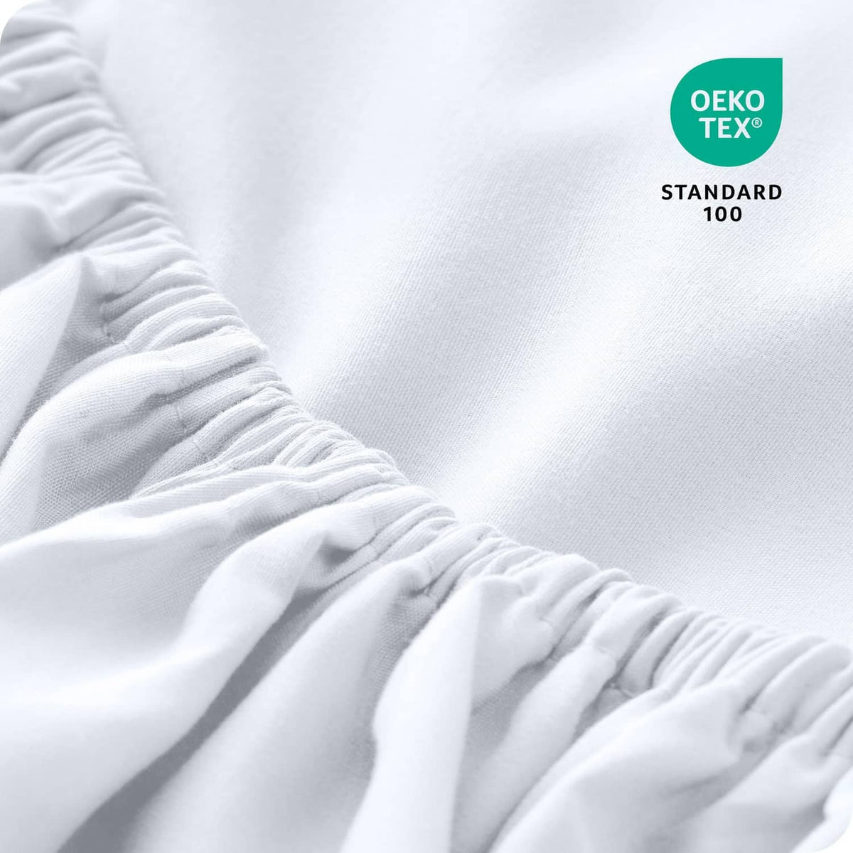 White microfiber fitted sheet close-up with gathered elastic edge detail