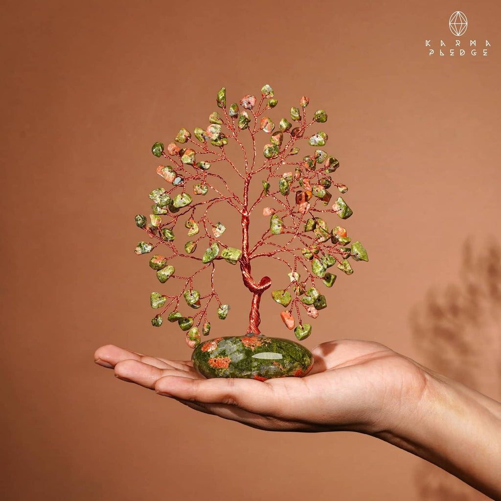 Unakite stone tree in rock base held in hand, green and orange crystal leaves