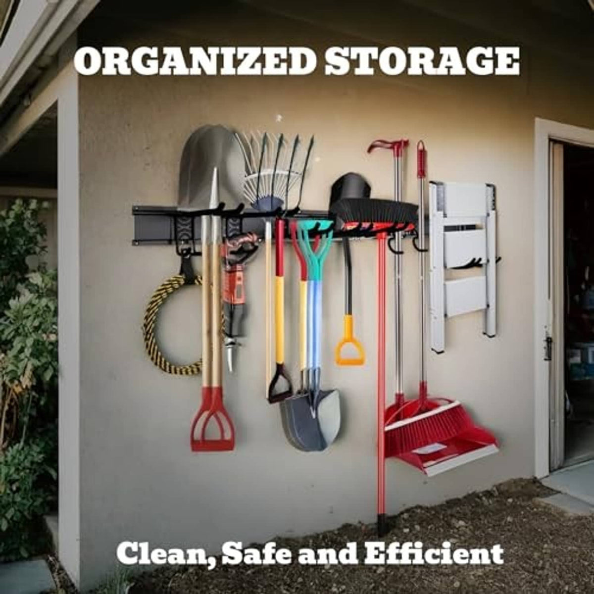 Black garage wall organizer rail with hooks holding tools and yard equipment