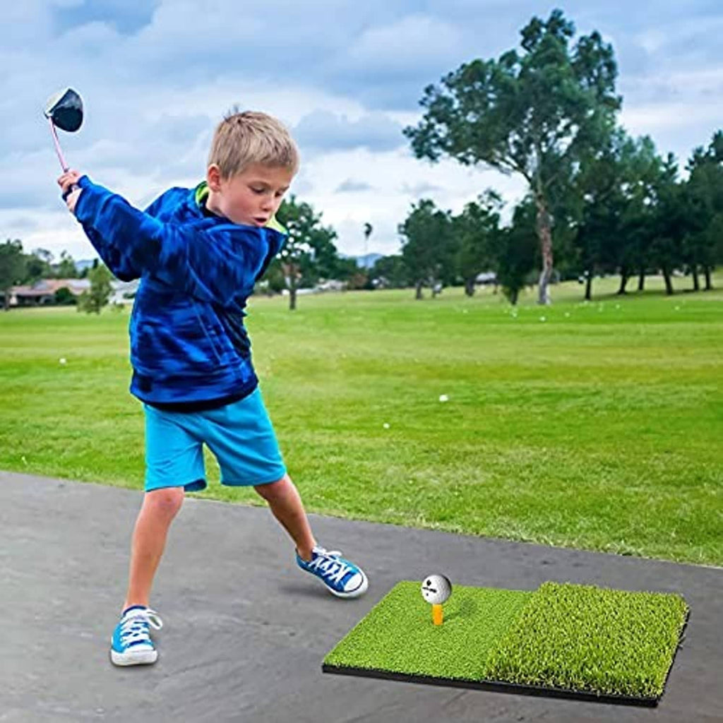Green golf practice mat on pavement with a child swinging a club and ball