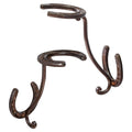 Rust-brown cast iron cowboy hat rack with three U-shaped hooks on a curved base.