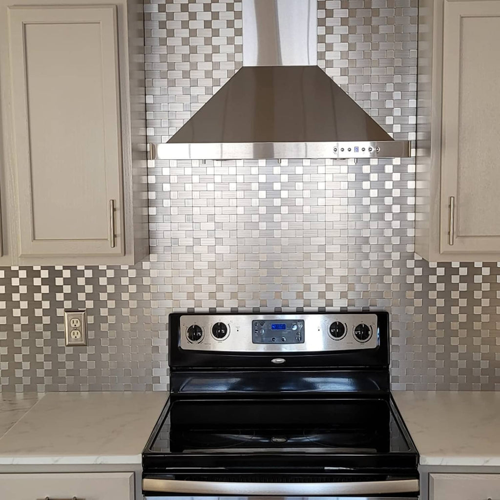 Metal backsplash tile sheet in gray and white checkered brick pattern behind black stove