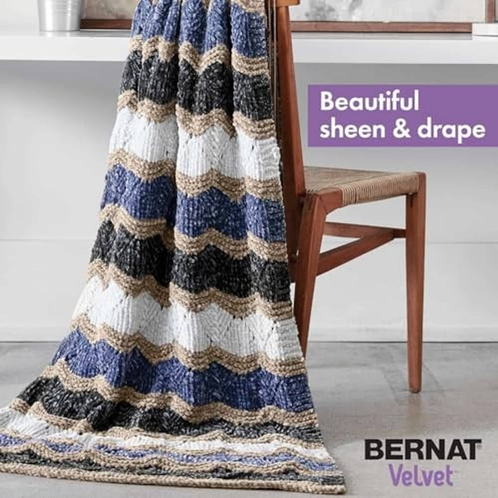 Striped knit throw blanket in blue, navy, white, and beige yarn