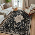 Rectangular black area rug with ornate beige floral medallion pattern
