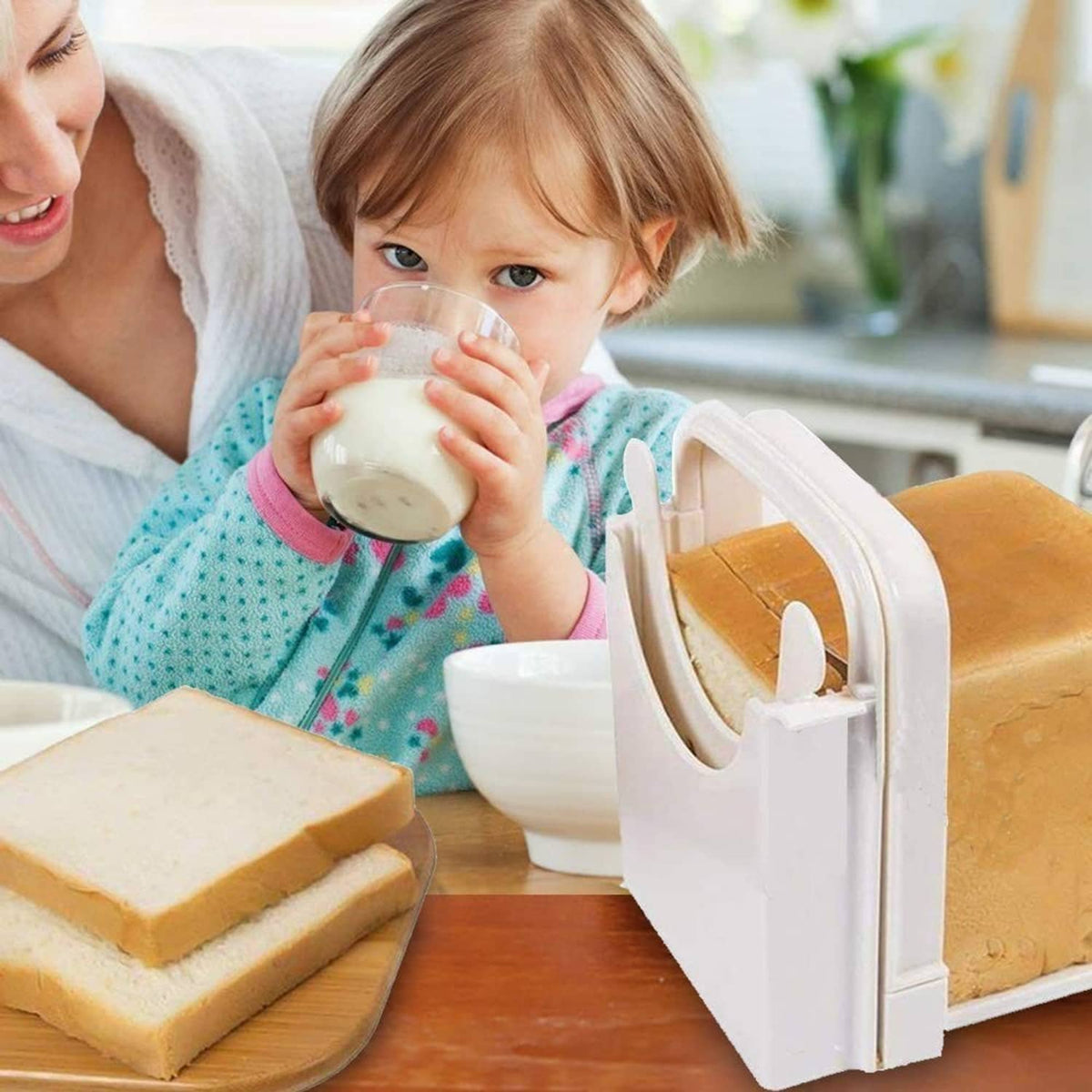 White bread slicer on a table with bread and a child holding a cup