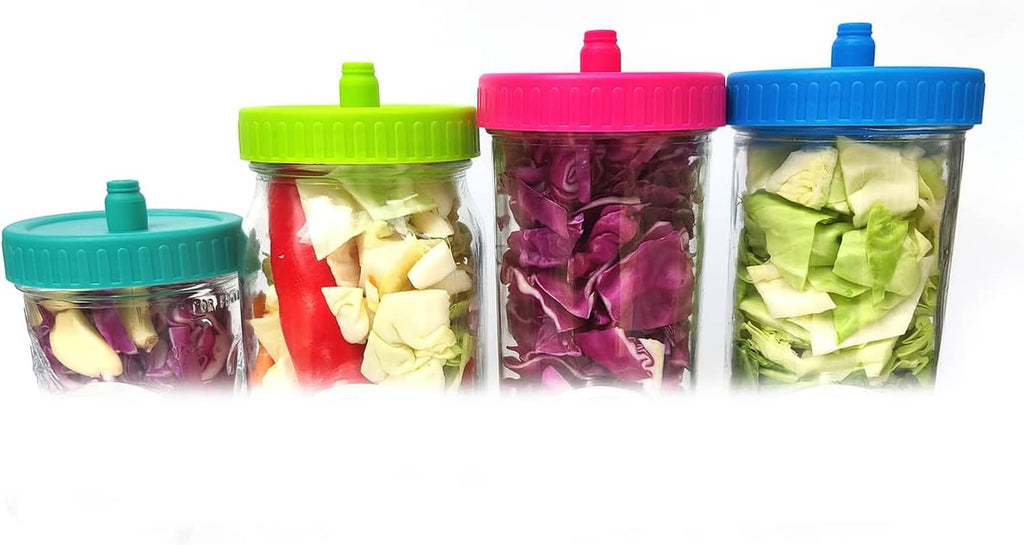 Mason jar fermentation set with colorful airlock lids and jars filled with chopped vegetables