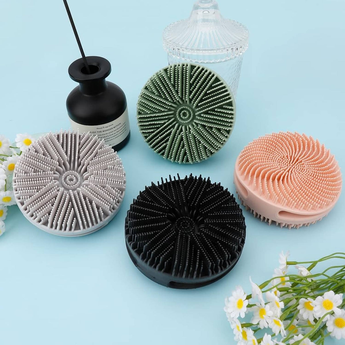 Silicone bath scrubber discs in white, black, green, and peach, circular bristle heads
