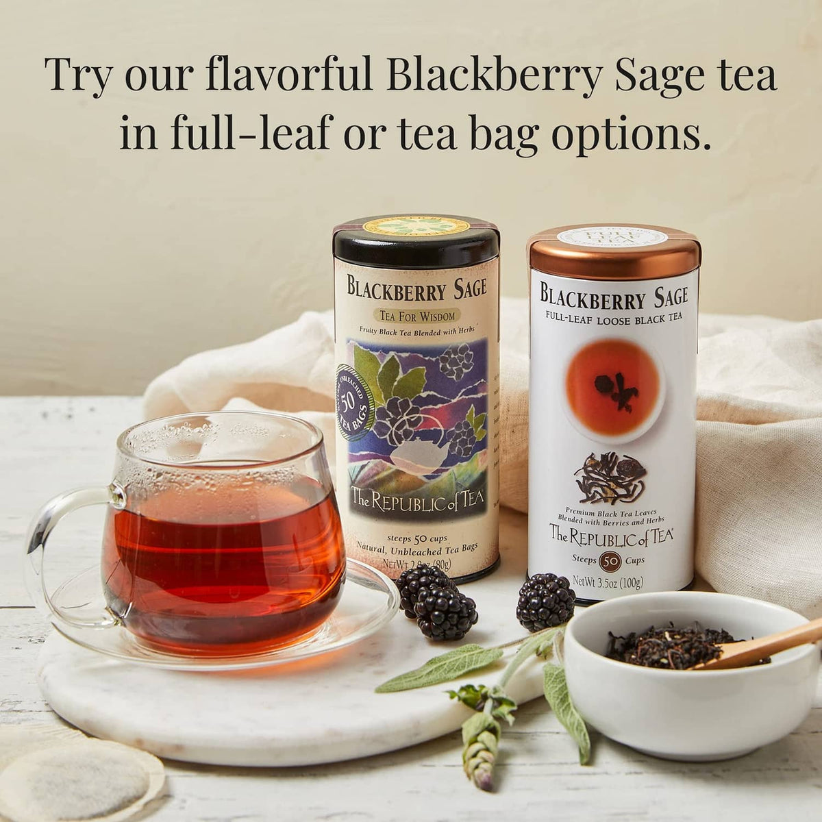 Blackberry Sage tea canisters with teapot, cups, and blackberries on a table
