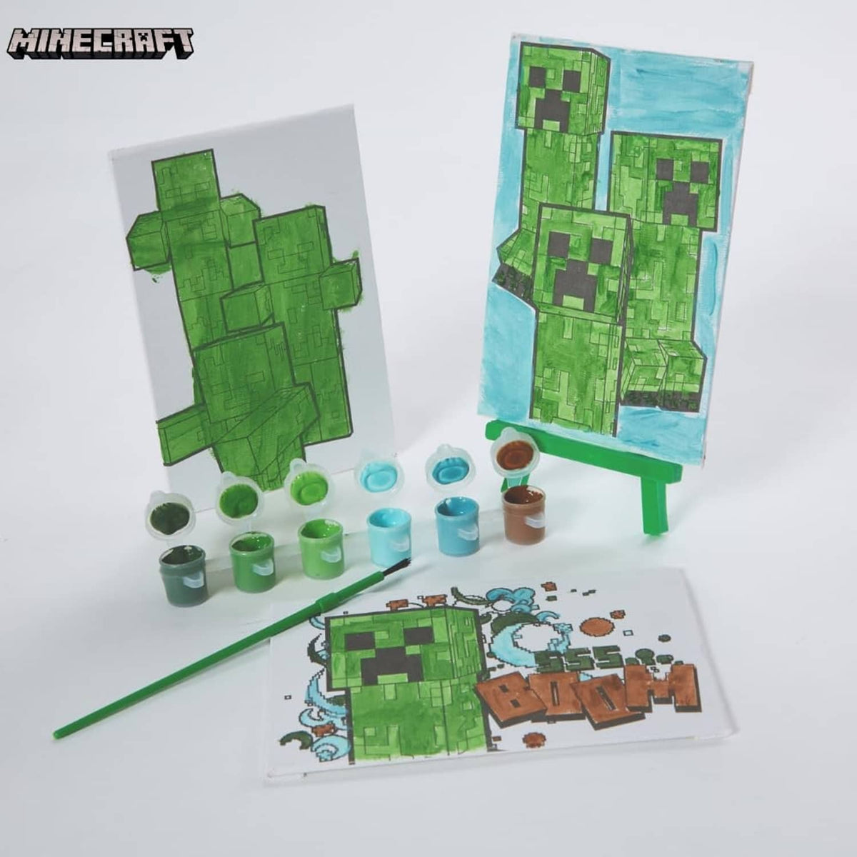Minecraft canvas painting kit with two painted canvases, paint pots, and green paintbrush