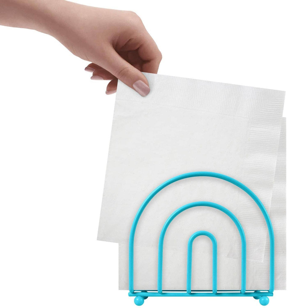 Turquoise arc napkin holder with rounded feet; hand placing a folded white napkin.