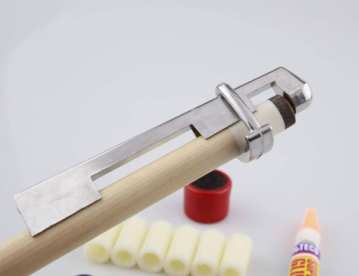 Pool cue tip tool applying a dark cue tip on a wooden cue with metal clamp