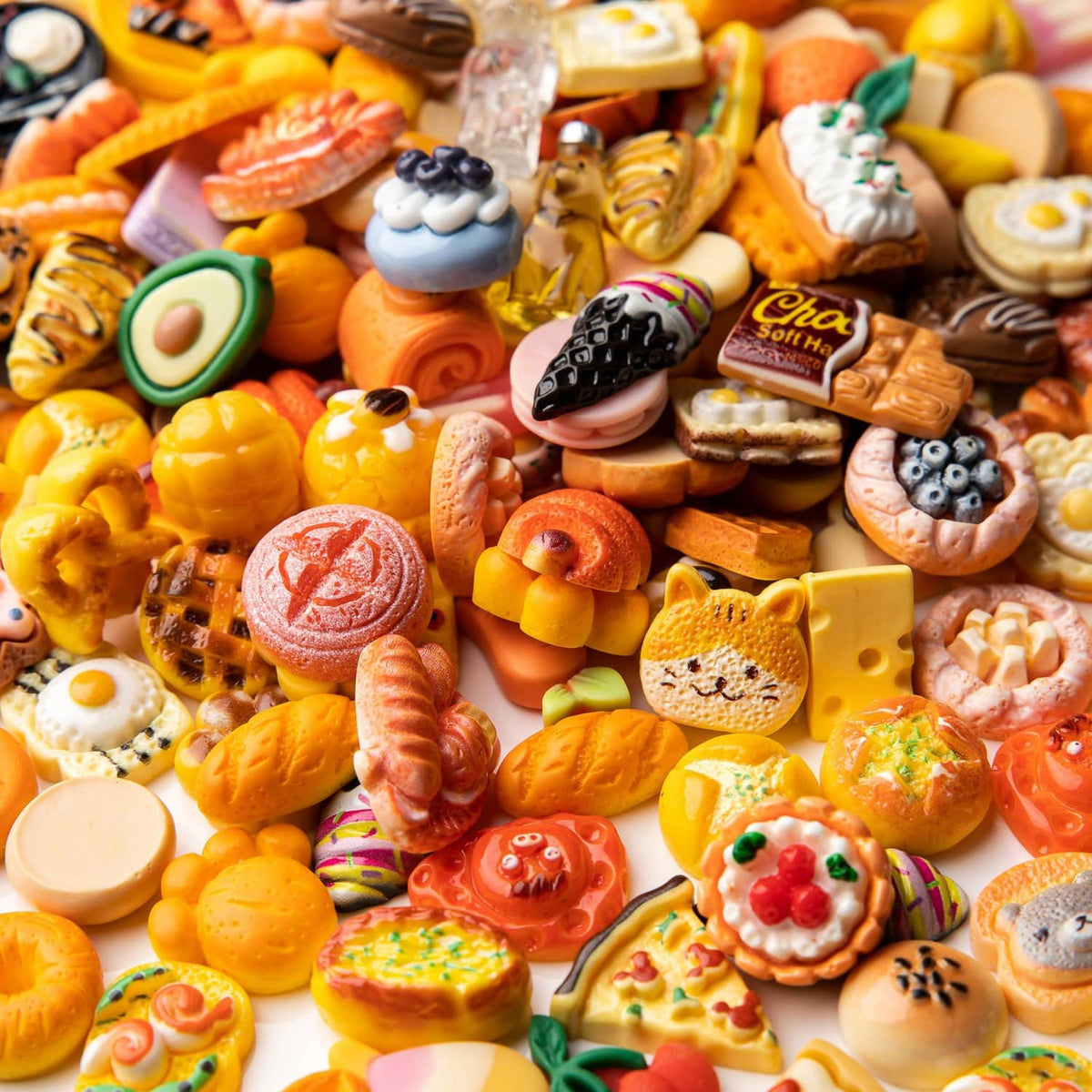 Assorted resin food charms pile with mini doughnuts, tacos, pizza slices, and desserts
