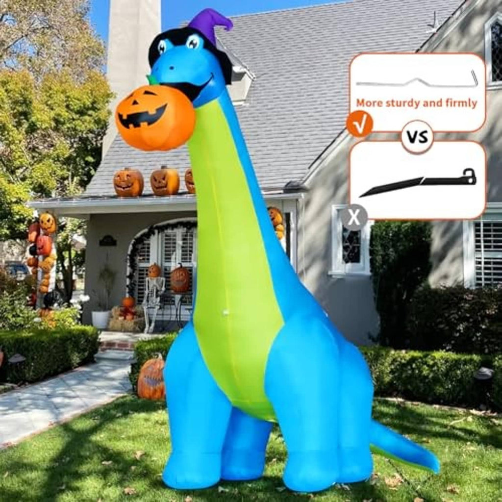 Inflatable blue dinosaur with green stripe, purple hat, holding jack-o'-lantern on lawn