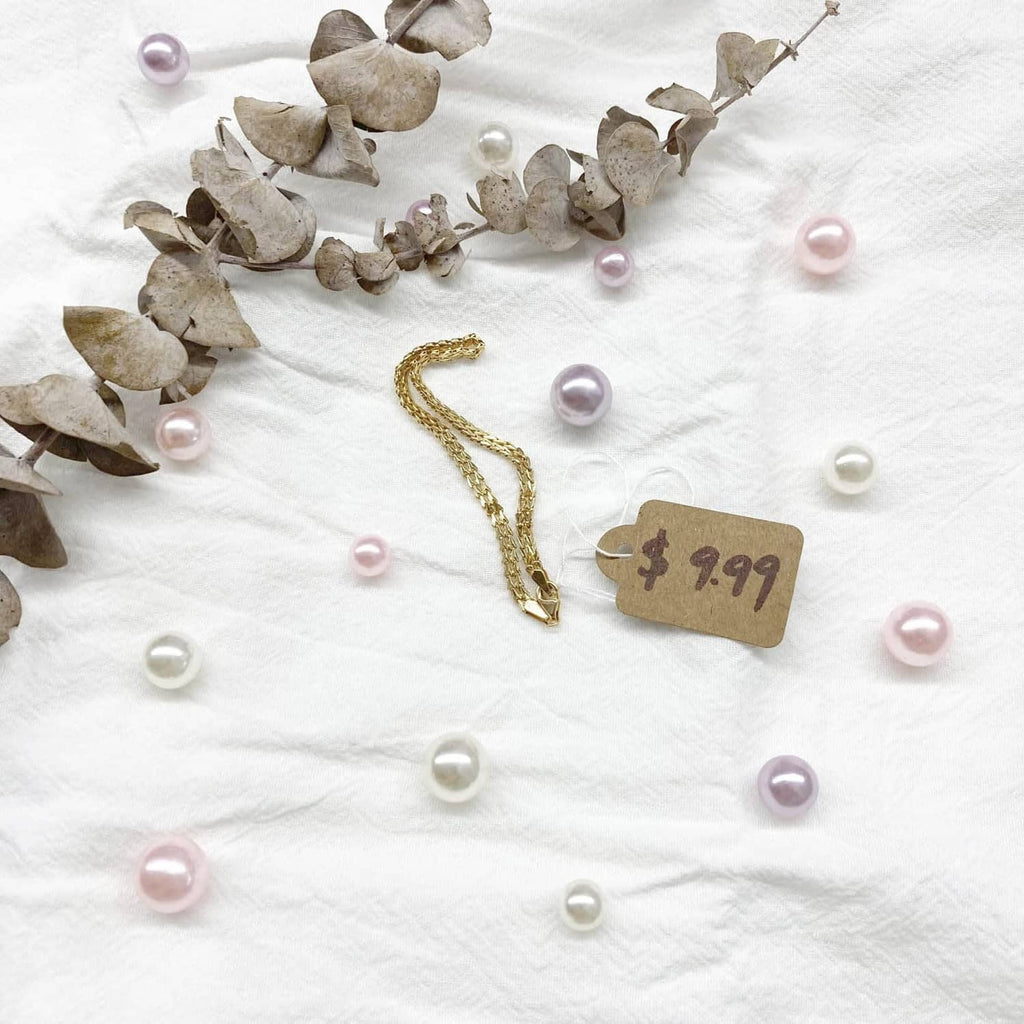 Kraft paper price tag with '$4.99' and string, with pearl bead decoration
