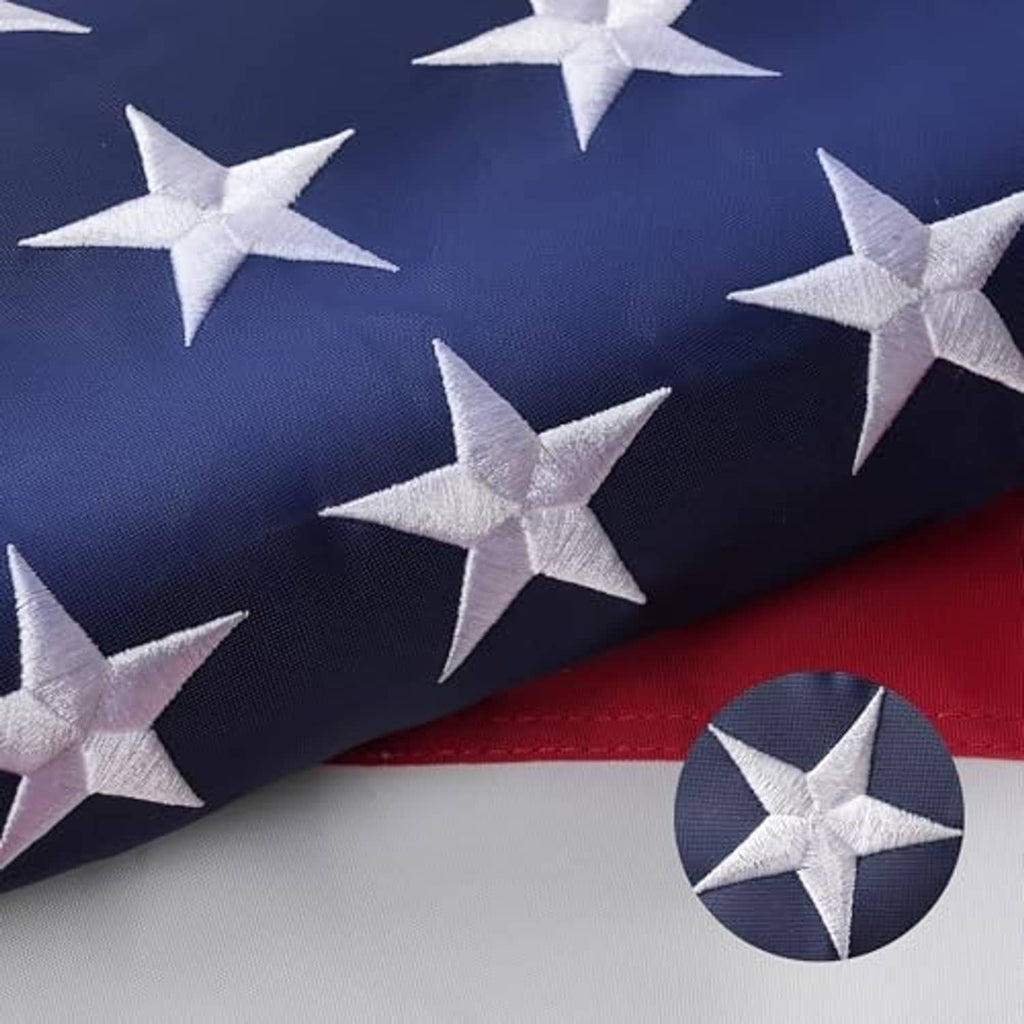 American flag with embroidered stars, red-and-white stripes, and a brass grommet detail