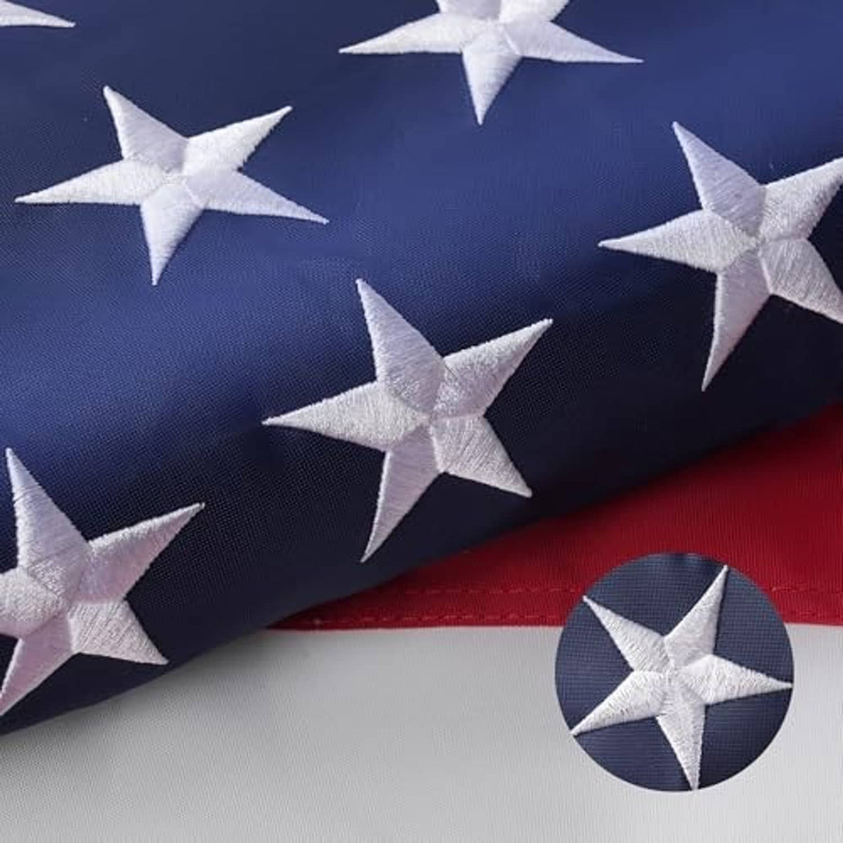American flag with embroidered stars, red-and-white stripes, and a brass grommet detail