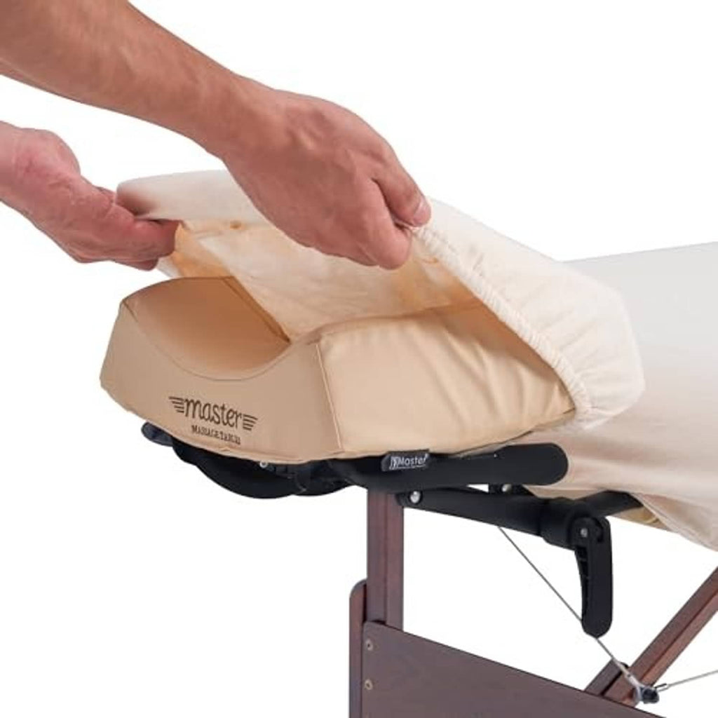 Light beige massage table cover being fitted over table corner, flannel fabric.