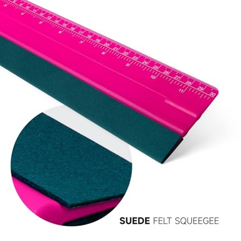 Close-up pink squeegee with dark green felt pad and ruler with measurement lines