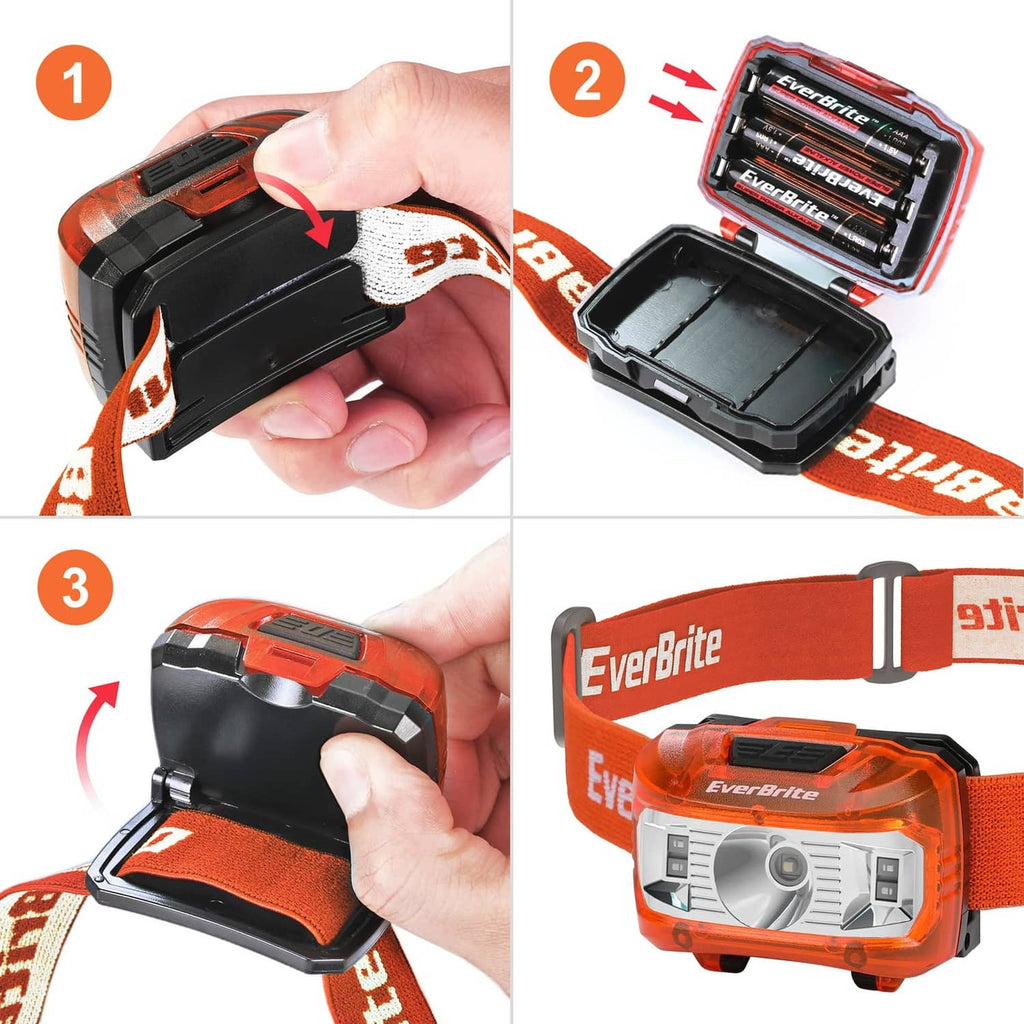 Orange kids headlamp with black housing, showing open battery compartment close-up.