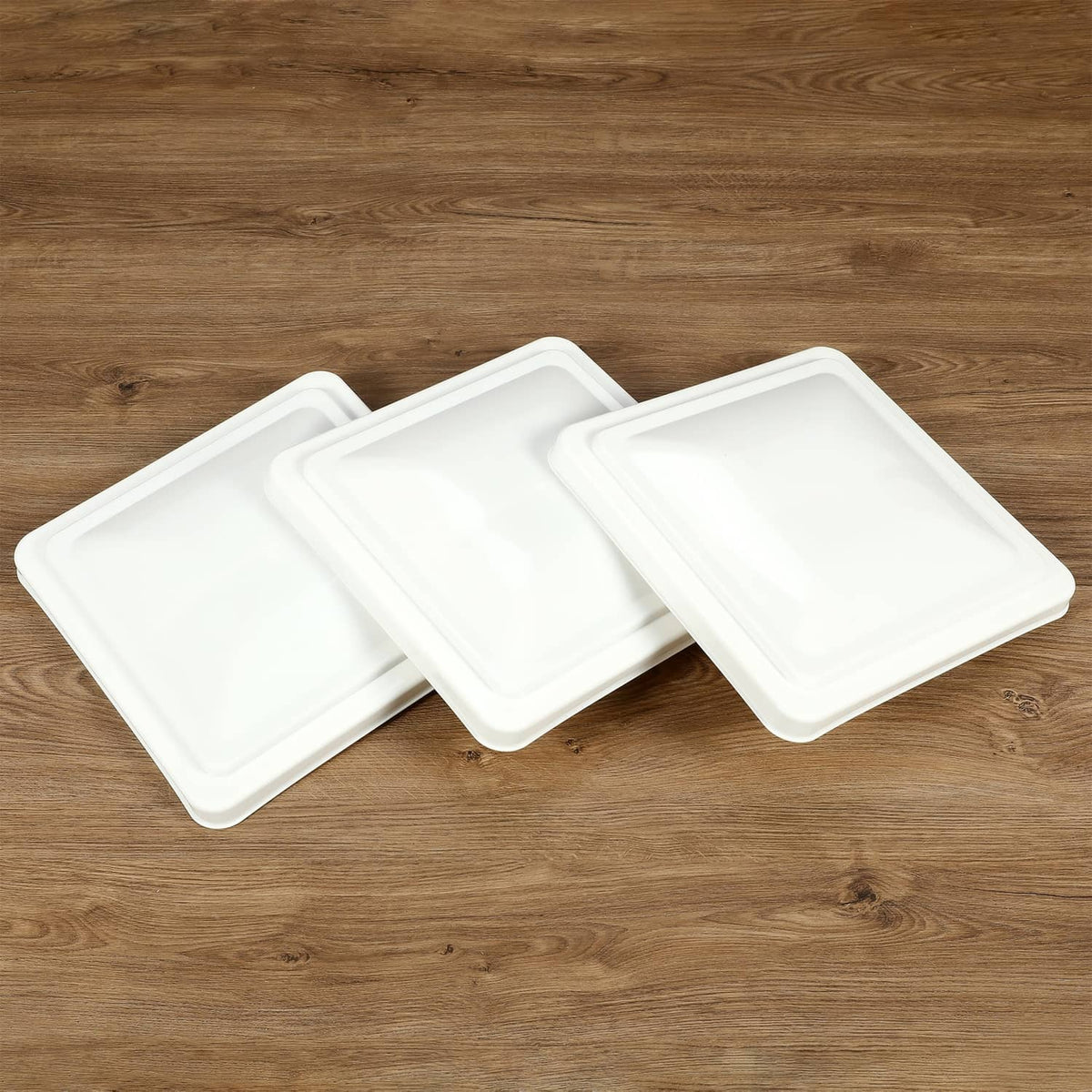Three white RV roof vent cover lids shown stacked with openings visible