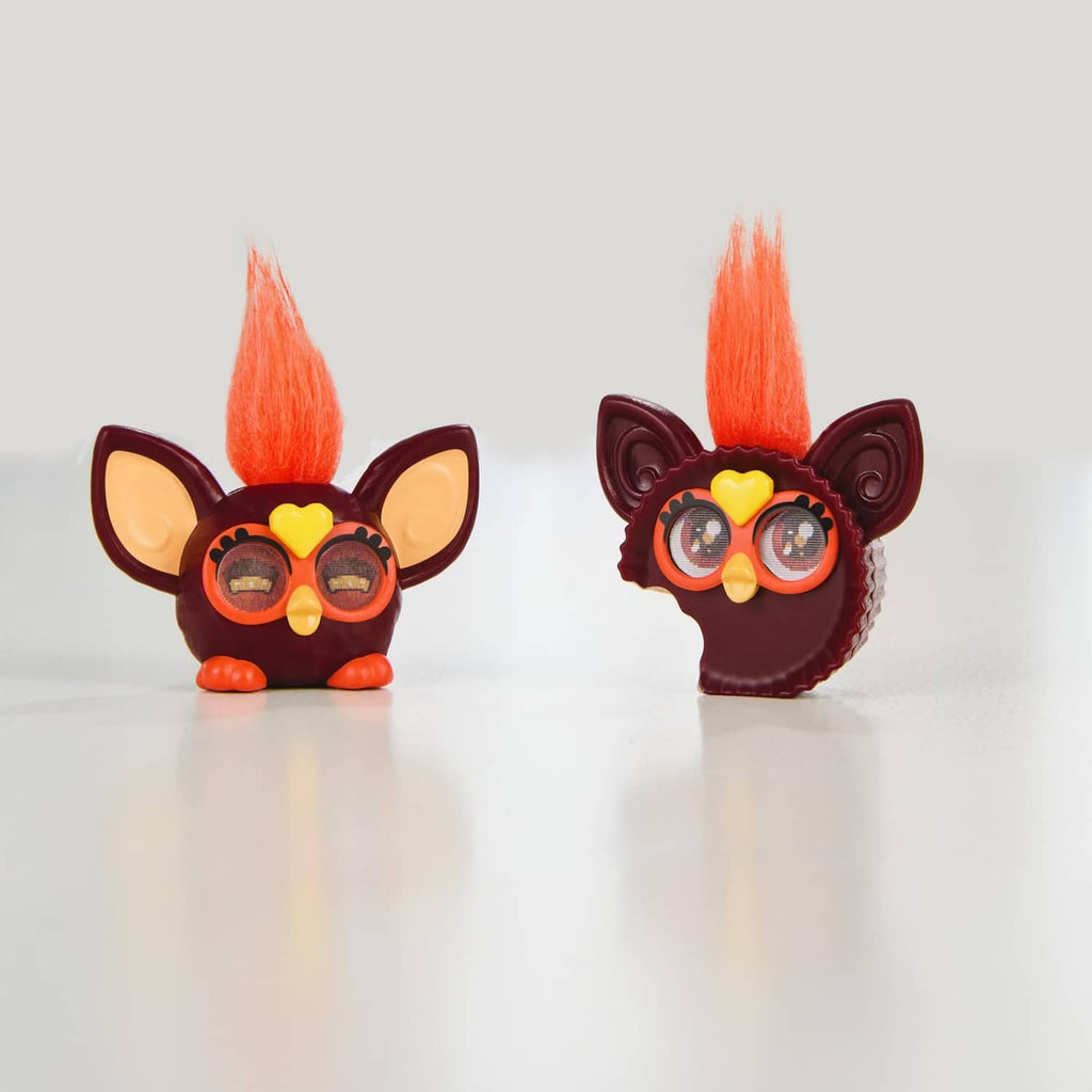 Two small brown Furby minis with orange mohawks, red heart eyes, and wing-like ears