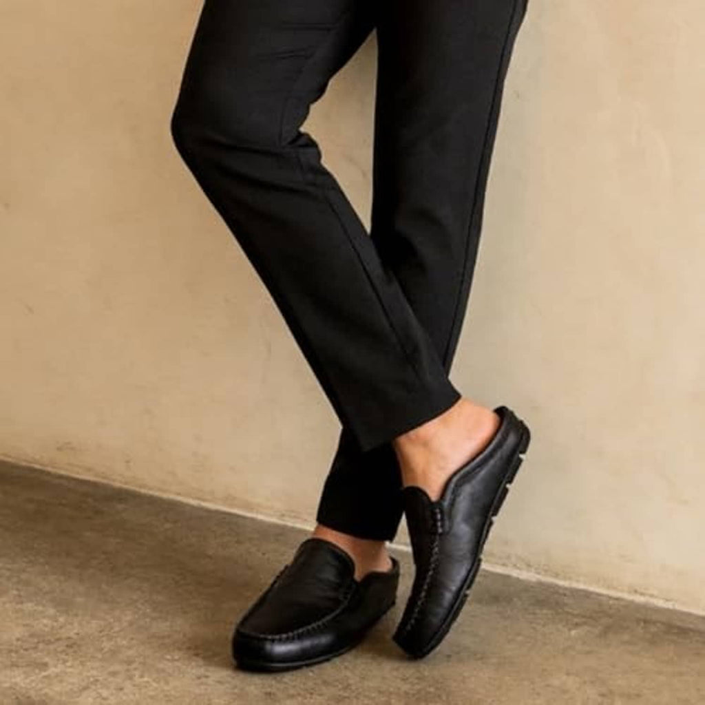 Black leather slip-on mules with low tread sole and stitched strap detail