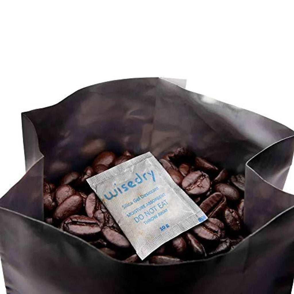 Wisedry silica gel desiccant sachet inside a transparent foil bag with dark items