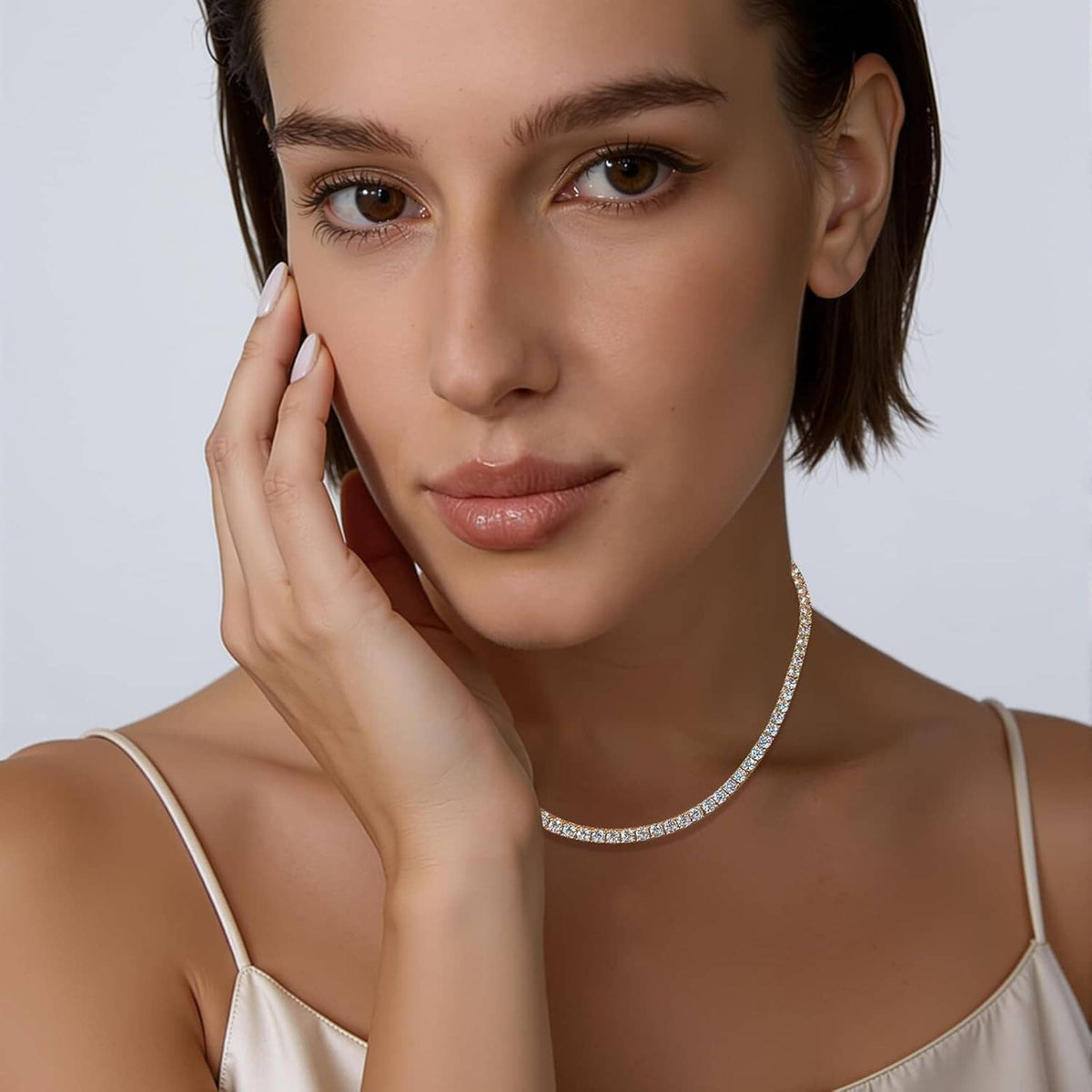 Wearing CZ tennis necklace with round clear stones along a gold-plated chain