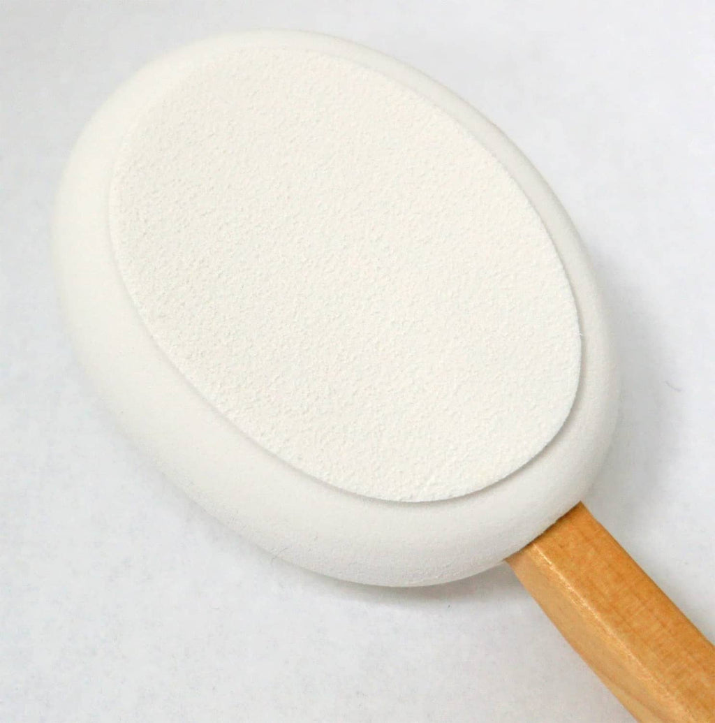 Round white lotion applicator pad attached to a wooden handle