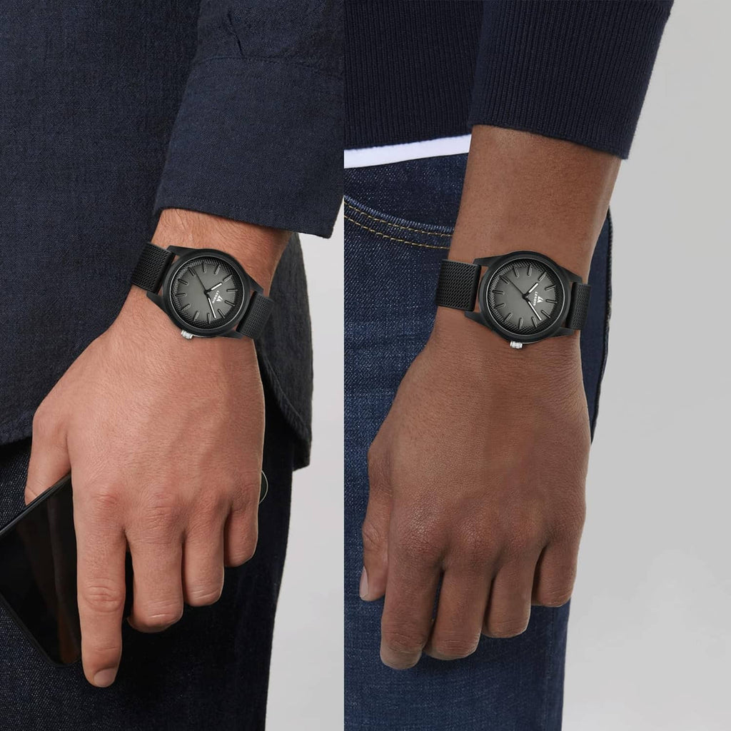 Black men's wristwatch on wrist with textured silicone band and round dark face.