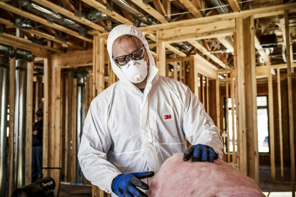 White 3M N95 respirator with Cool Flow valve, worn by worker, workshop setting
